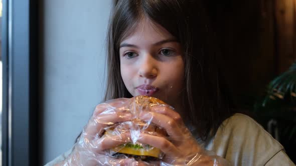 Cute Little Girl Teenager Eating Burger in Cafe