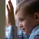 Sad Little Boy Sitting At Window And Looking At Snow - VideoHive Item for Sale