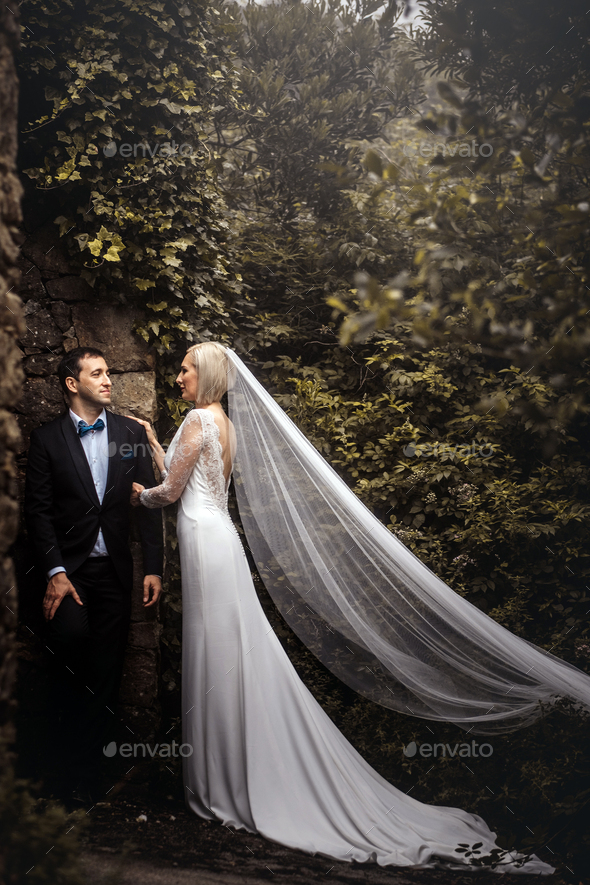 Lovely couple of newlyweds - bride and groom hugging at a beautiful mystery forest.
