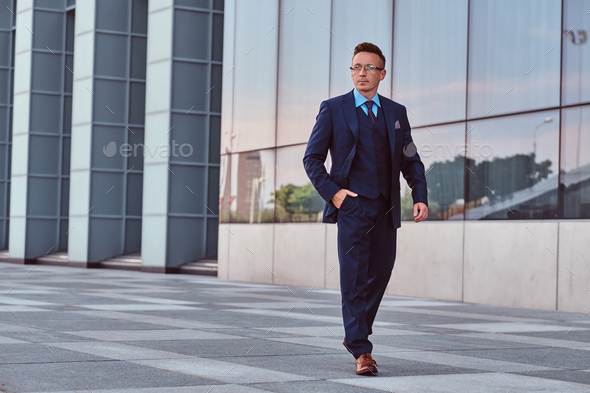 Confident businessman dressed in an elegant suit standing outdoors against cityscape background. - Stock Photo - Images