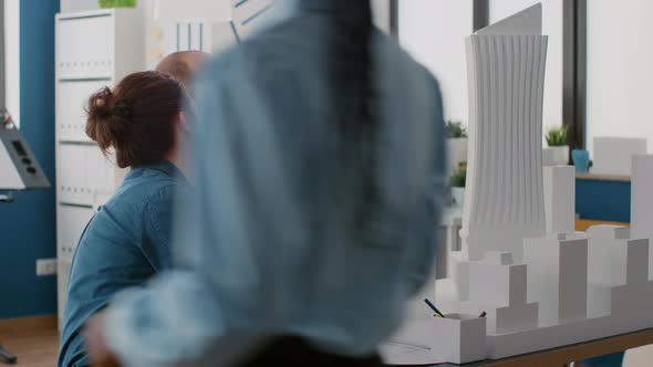 Architects Using Smartphone to Design Construction Layout with Building Model and Blueprints alt