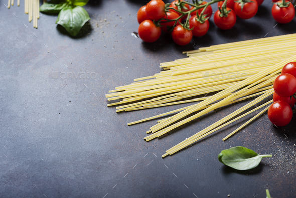 spaghetti, tomato, basil and garlic on the black table - Stock Photo - Images