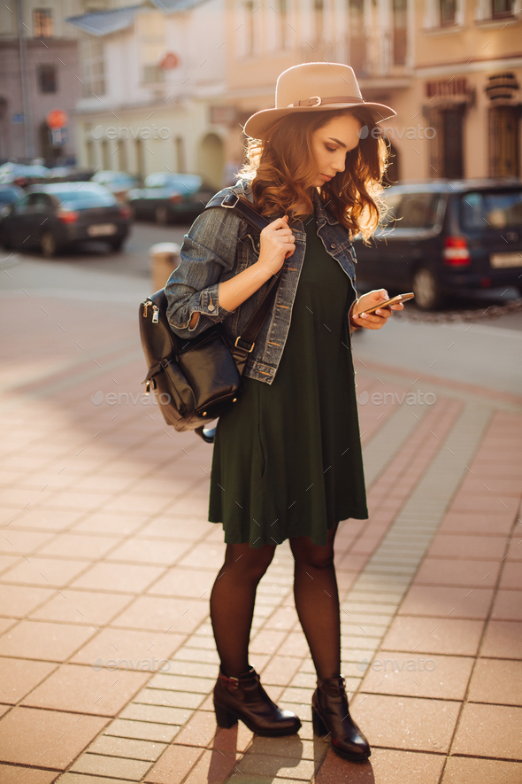 Stylish woman in hat, walking after shopping and using smar tphone - Stock Photo - Images