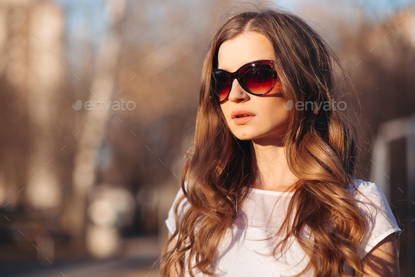 Beautiful seductive woman in sunglasses walking at street - Stock Photo - Images