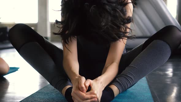 Young Caucasian Woman Stretching and Smiling at Camera on the Gym Floor alt