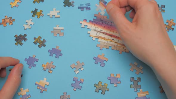 A Group of Puzzles, Hands on Blue Table Background. Puzzle Game, Preschool Education. Puzzle Pieces
