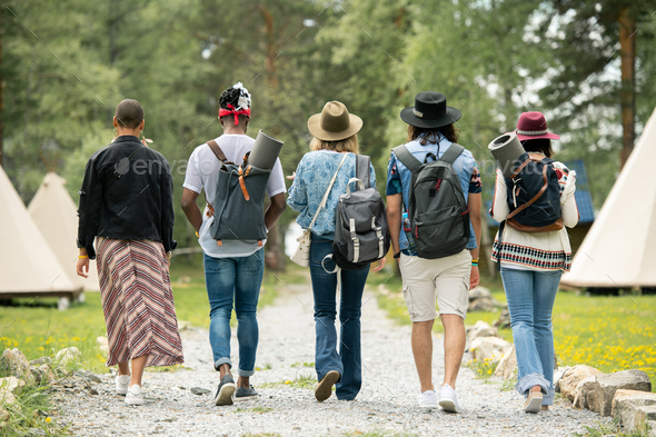 Young people walking over festival campsite