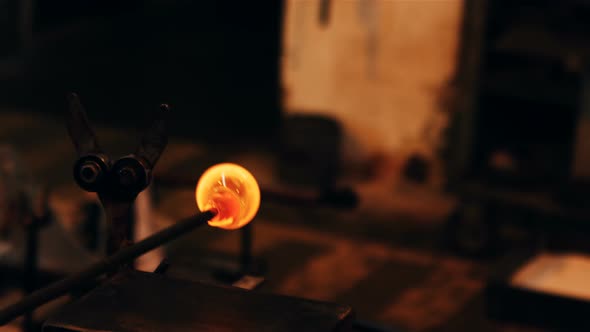 Close-up of molten glass being shaped alt