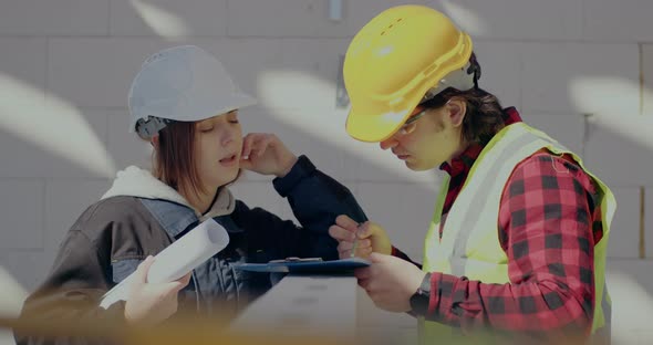 Male Contractor Writing on Clipboard Discussing with Female Architect alt
