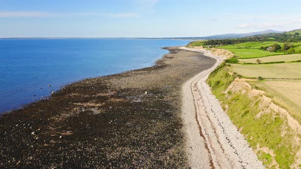 Bright Blue Sea Sea At The Village Of Trefor With Lush Field And Rough Coast In Llyn Peninsula, Wale alt