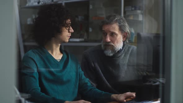 Male Designers Discussing Data on Computer alt