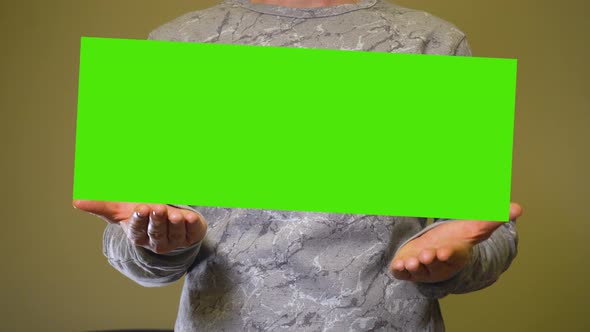 Man Raises Empty Green Screen Chromakey Banner Over Hands