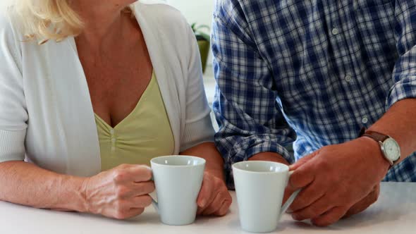 Couple interacting while having a cup of coffee alt