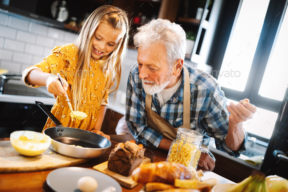 Grandfather and his grandchildren spendig happy fun time in kitchen
