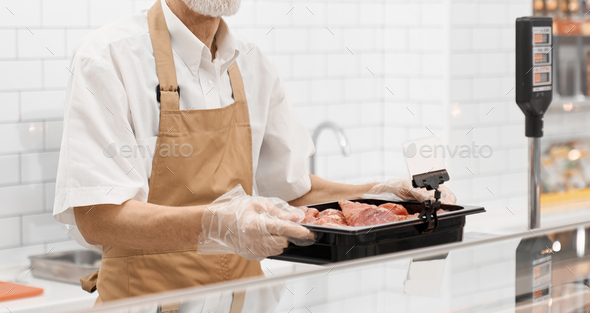 Incognito male butcher demonstrating meat - Stock Photo - Images