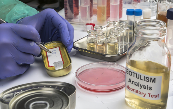 Experienced laboratory scientist writes on a canned food label - Stock Photo - Images