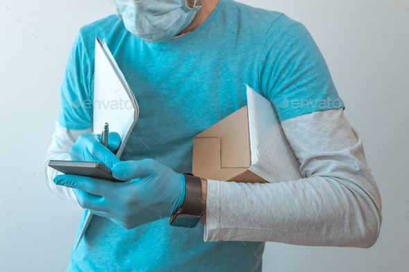 Delivery man with protective clothing using smartphone - Stock Photo - Images