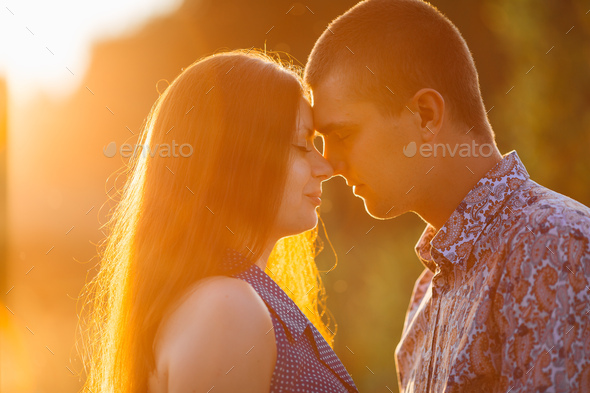 Portrait of brunette woman and man kissing and embracing face to face - Stock Photo - Images