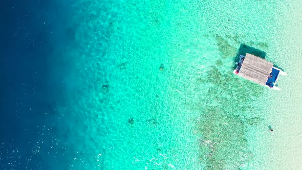 Touring boat with straw roof approaching to shore of tropical island in Fiji, carrying newcomers on alt