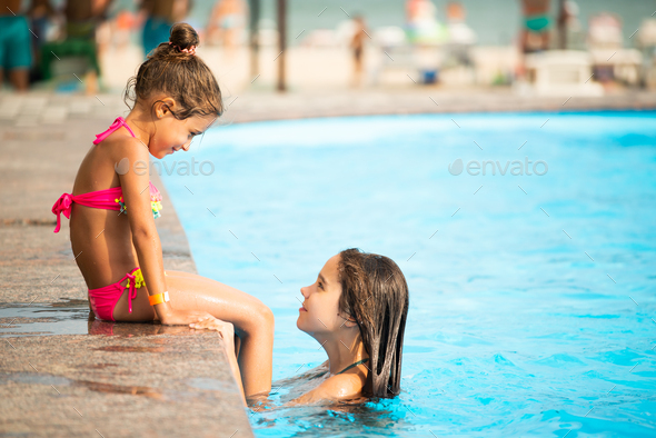 Beautiful little girl swims in the pool , cute little girl in pool in sunny  day.little girl . Stock Photo