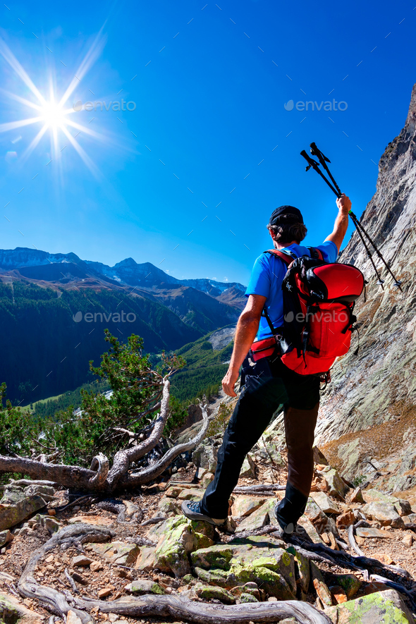 Hiker takes a rest observing a mountain panorama. - Stock Photo - Images