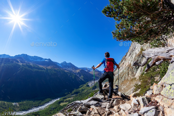 Hiker takes a rest observing a mountain panorama. - Stock Photo - Images