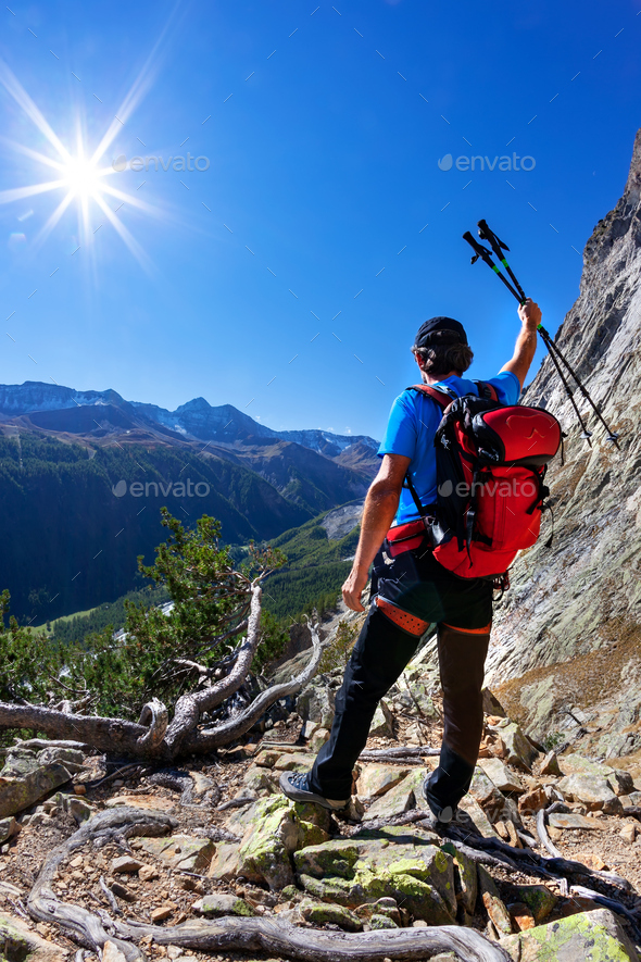Hiker takes a rest observing a mountain panorama. - Stock Photo - Images