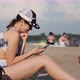 Young Woman Uses a Smartphone on the Beach - VideoHive Item for Sale
