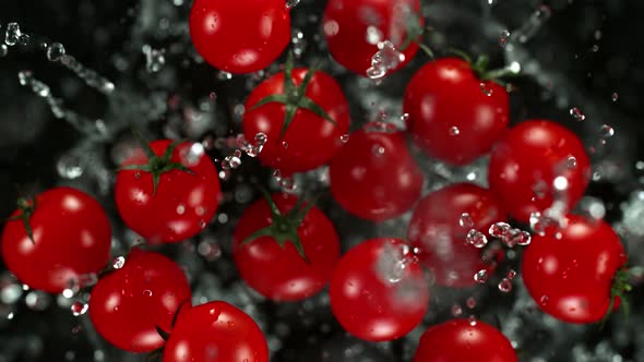 Super Slow Motion Shot of Flying Cherry Tomatoes with Water Towards the Camera at 1000Fps alt