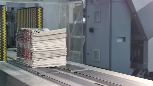 Newspapers at the conveyor belt of a printing factory alt