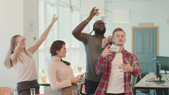 Young People Making Rain with Money at Coworking Space. Money Flying in Air alt