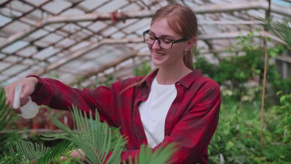 Girl with Glasses Sprays Plants From a Splash or Spray