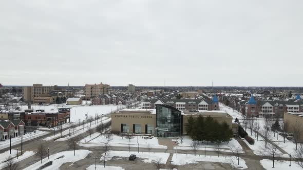 Panoramic view of cityscape in winter. Snow covering the grass. Gray cloudy sky.