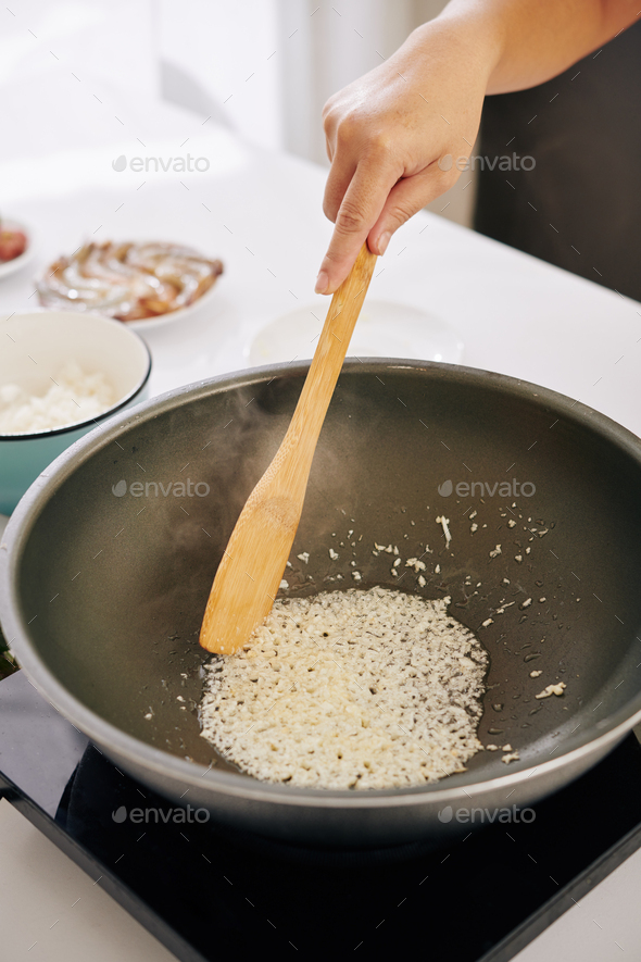 Woman frying diced onion
