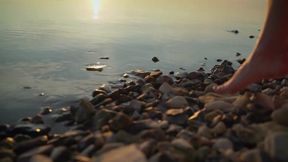 Women's Feet Go To the Water on the Stones. Girl Goes Barefoot on the Stones of a Mountain River alt