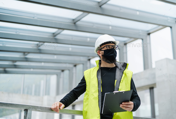 Portrait of worker with face mask at the airport, holding clipboard