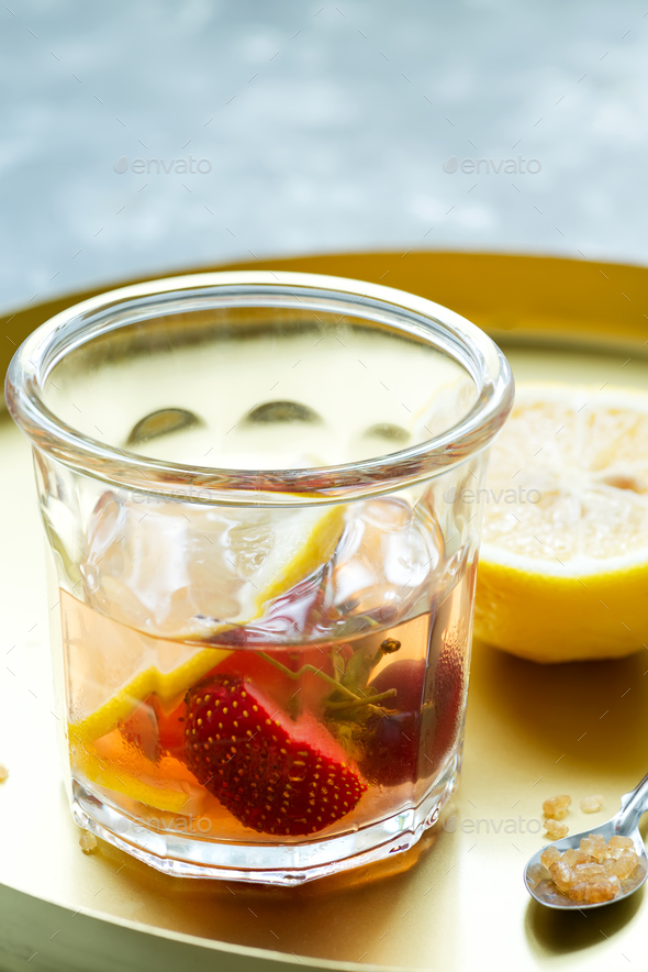 Homemade refreshing cold cocktail from natural berries and lemon fruits in a glass on a light grey - Stock Photo - Images