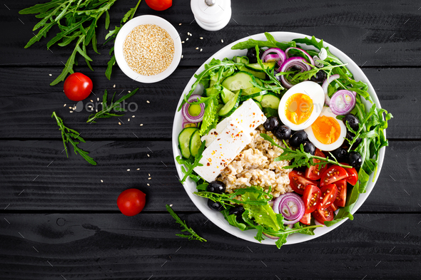 Greek style healthy breakfast bowl with oatmeal porridge and fresh vegetable salad - Stock Photo - Images