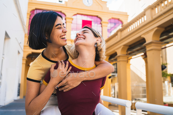 Loving lesbian couple having fun at the street.