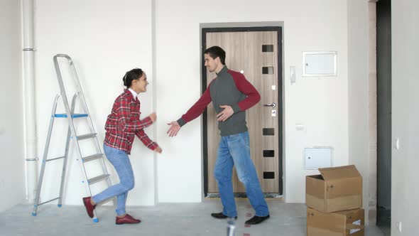 Young Happy Couple Moving in to Their New Home and They Dancing Next to Boxes
