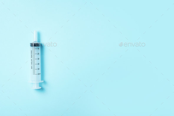 Syringe and needle on blue background. Injections and vaccination concept. Health protection