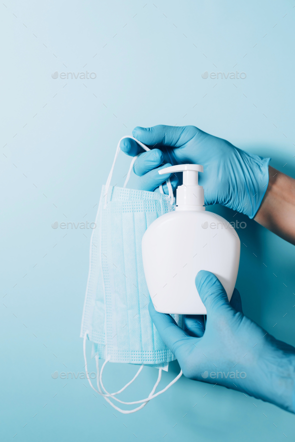 Products to stay safe during pandemic covid19 quarantine. Hands in blue gloves holding sanitiser gel