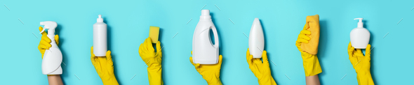 Hands in gloves holding detergent bottles on blue background. Banner with copy space. Chemical - Stock Photo - Images