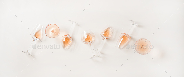 Flat-lay of rose wine in glasses over plain white background - Stock Photo - Images