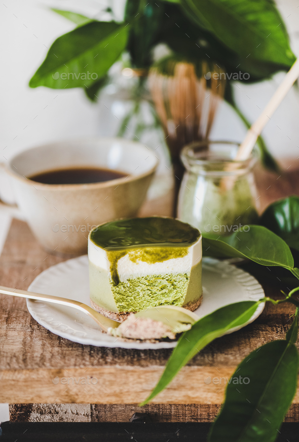 Green matcha cheesecake and coffee in mug on kitchen counter - Stock Photo - Images