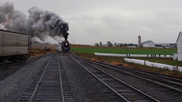 Steam Locomotive Pulling Freight Pulling into Yard with Smoke and Steam