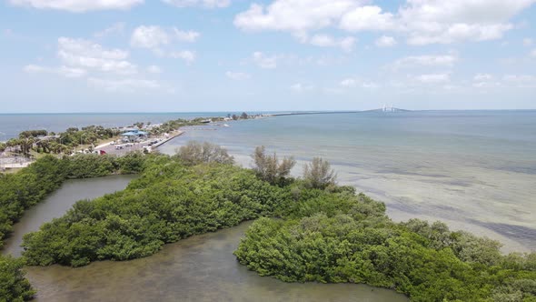 aerial of a secluded mangrove bay with Sunshine Skyway bridge in the distinct background alt