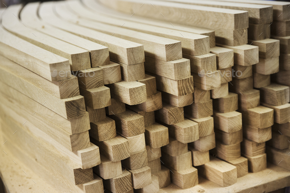 Close up of a stack of planed, curved square-edge timber pieces.