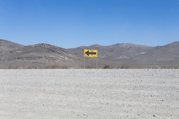 Bullet riddled arrow sign in desert, Black Rock Desert, Nevada