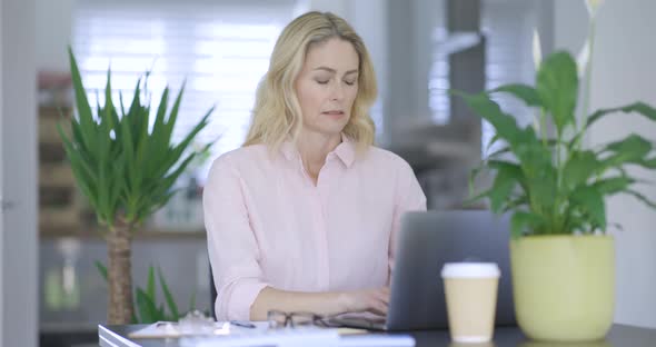 Nervous businesswoman working on laptop